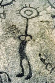 A closeup of one of the petroglyphs carved into the rock. THe symbol resembles a person.